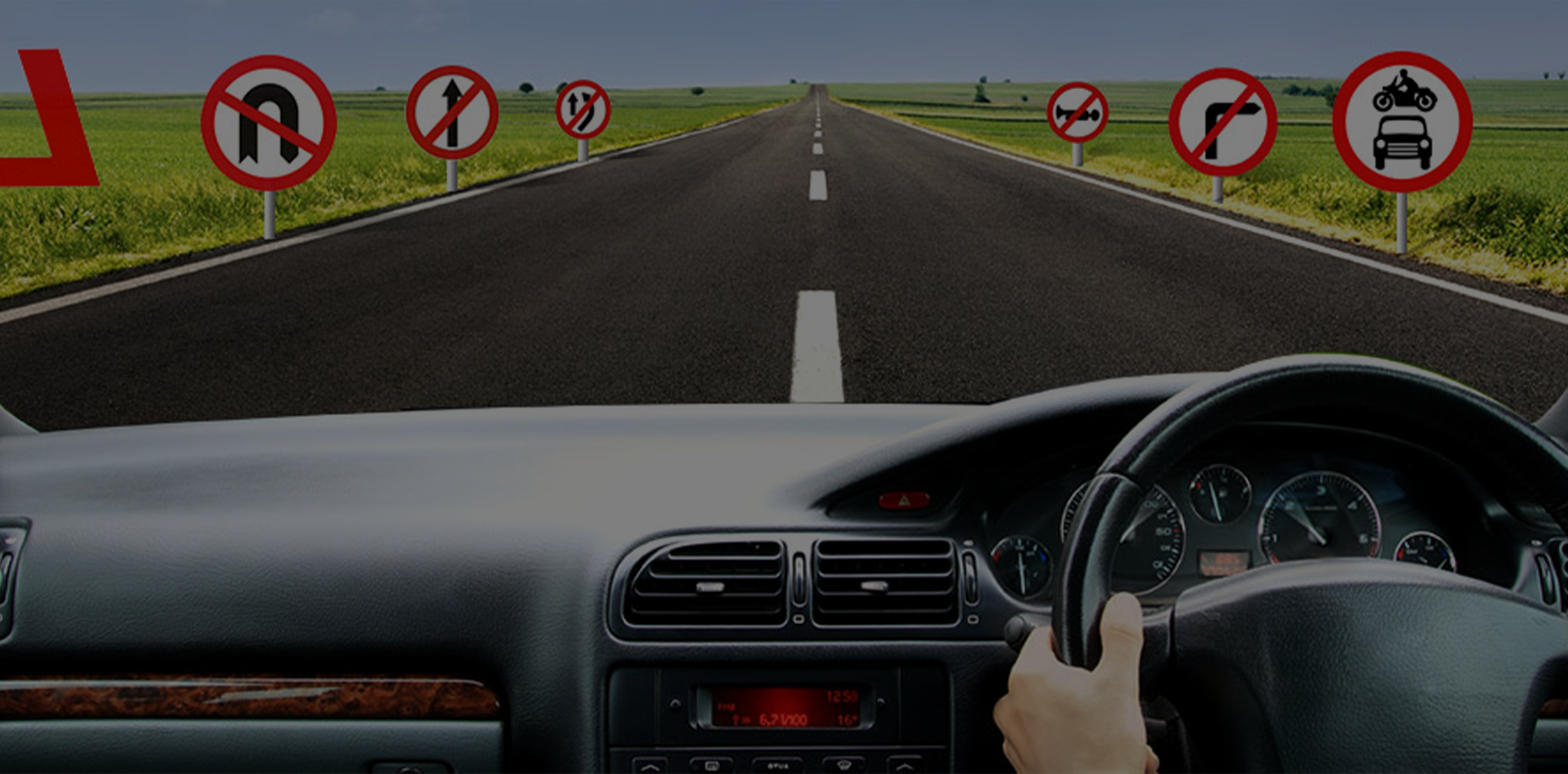 Car dashboard view driving on a two-lane road with no left turns allowed.